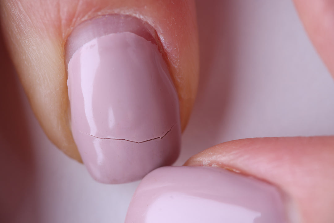 Broken pink nail with a crack