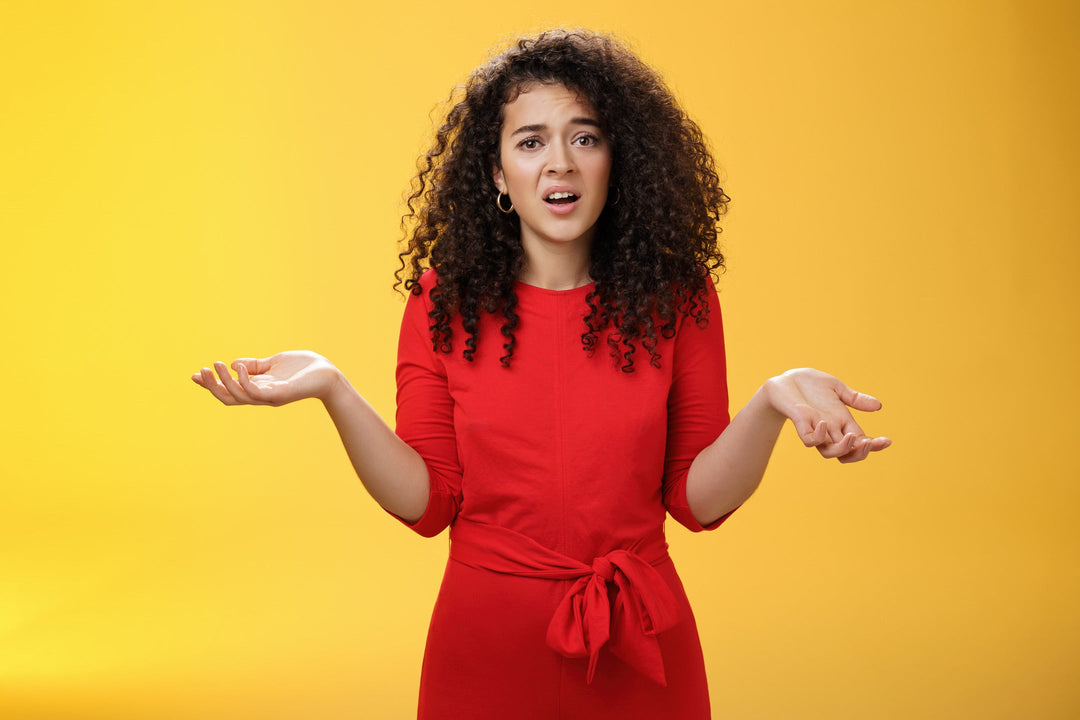 Woman wearing a red dress holding her hands out as if to ask a question